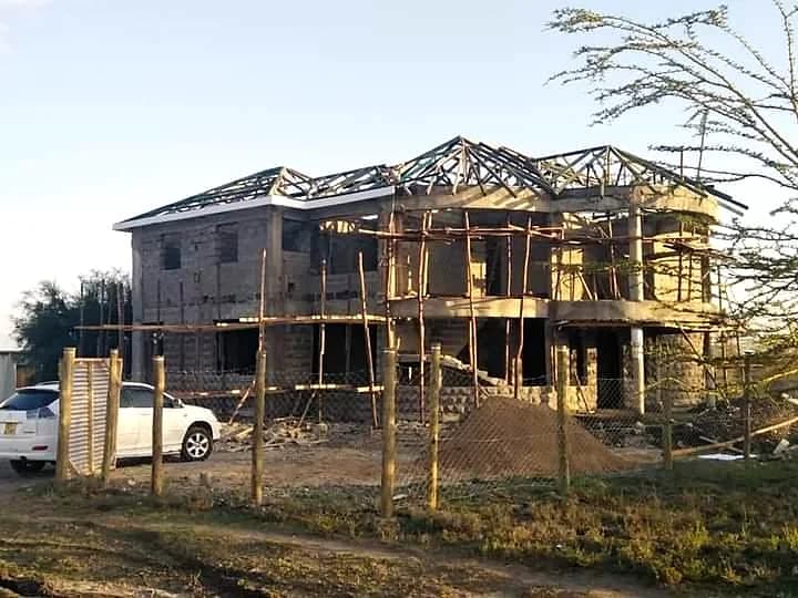 Multi-storey structural framing, masonry infill, and roofing erection.