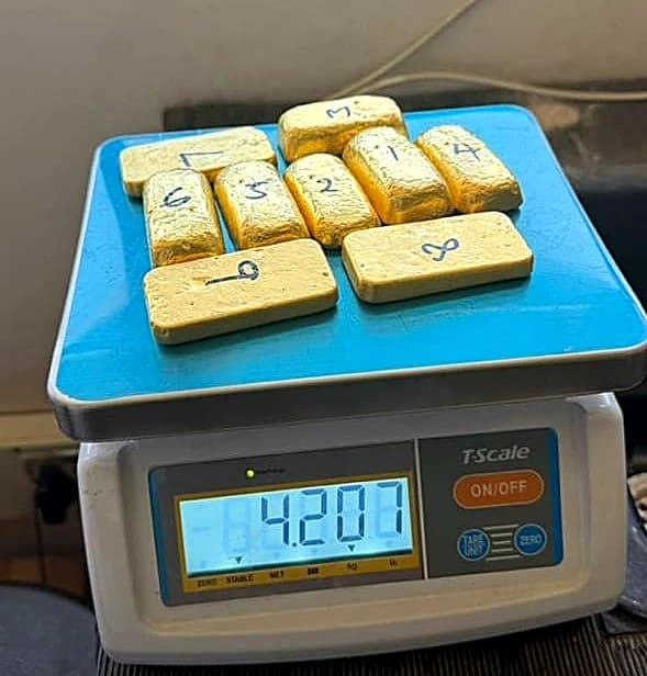 Refined gold bullion bars weighed on certified analytical scale displaying 4.207 kg